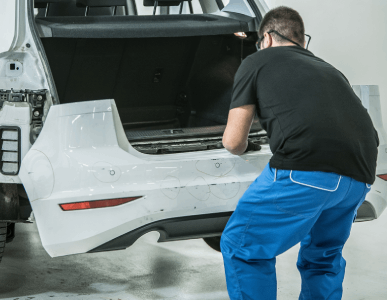 Technician working on a vehicle rear panel